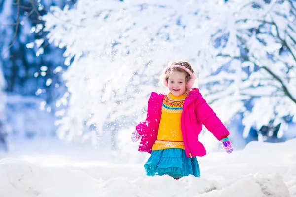 Kleine meisje spelen sneeuw bal vechten in winter park — Stockfoto