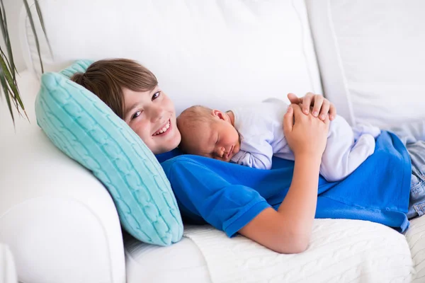 Child holding newborn sibling — Stock Photo, Image