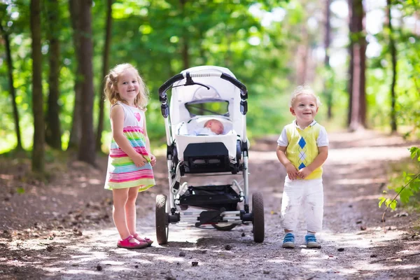 Kinder schieben Kinderwagen mit Neugeborenem — Stockfoto