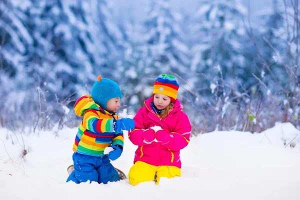 Barn leker i snöiga vinter park — Stockfoto