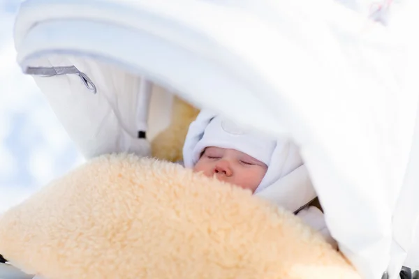 Niño recién nacido durmiendo en cochecito en invierno — Foto de Stock