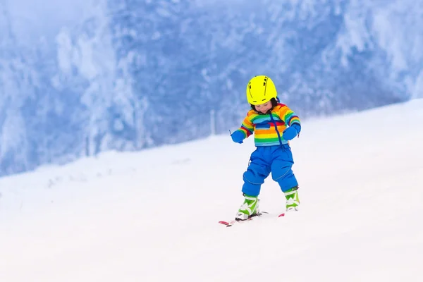 Małe dziecko na nartach w górach w zimie — Zdjęcie stockowe
