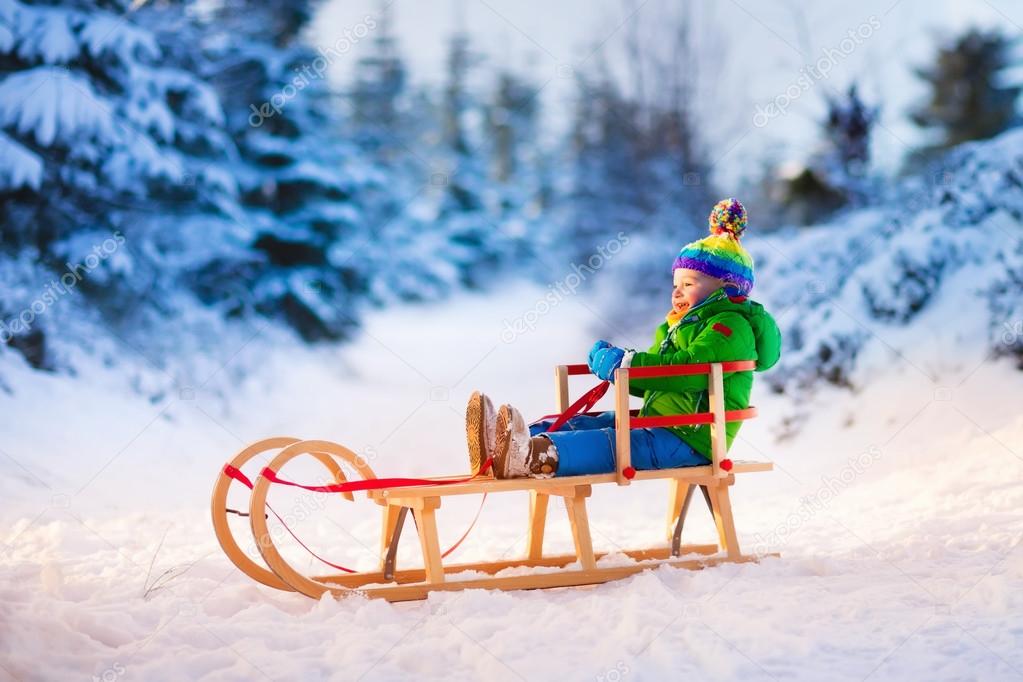 Little boy enjoying sleigh ride.