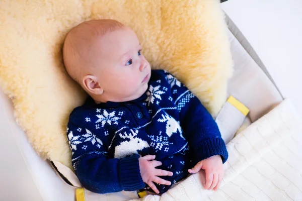 Little baby in nordic sweater on sheepskin muff — ストック写真