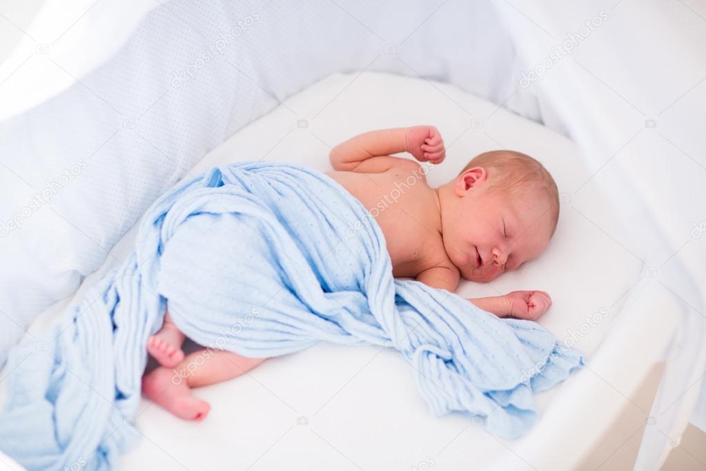 Cute newborn baby in white bed