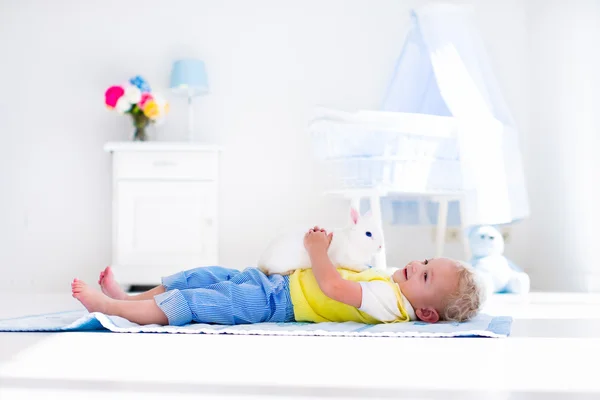 Pequeño niño jugando con conejo mascota —  Fotos de Stock