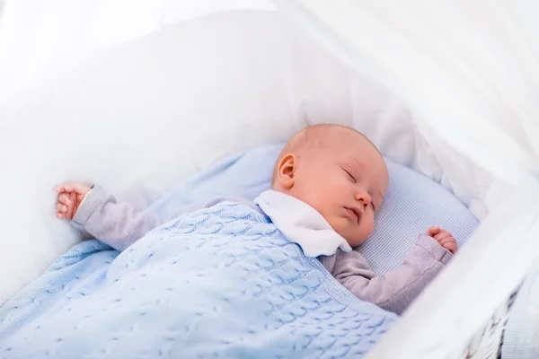 Niño en una cuna debajo de una manta de punto —  Fotos de Stock