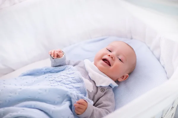 Babyjongen in een wieg onder gebreide deken — Stockfoto