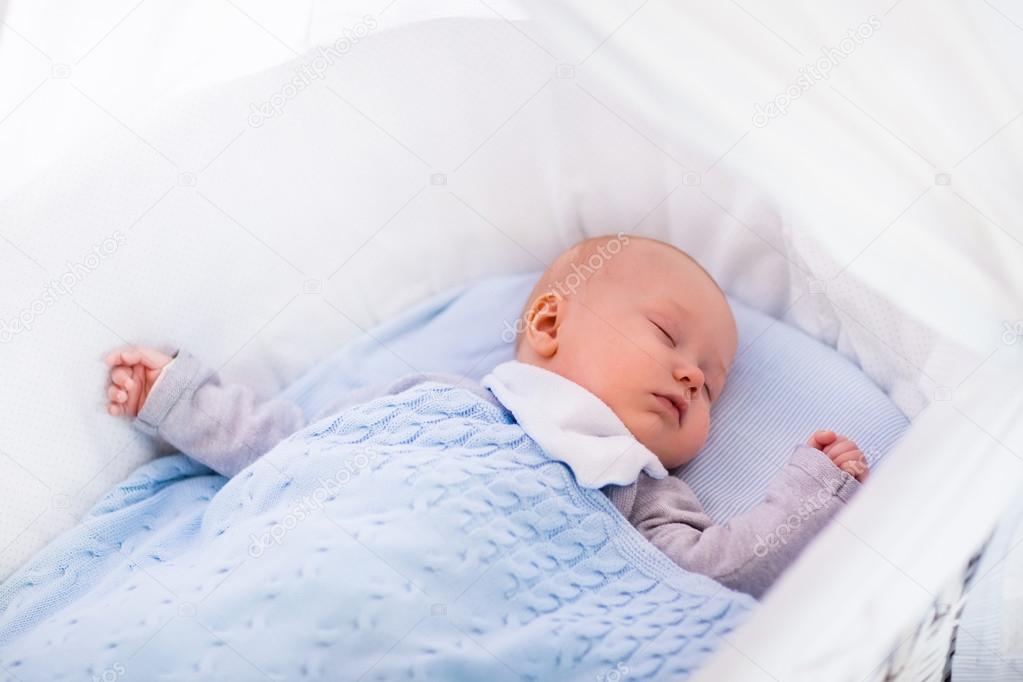 Baby Boy In A Crib Under Knitted Blanket Stock Photo