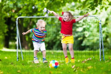 Okul bahçesinde futbol oynayan çocuklar
