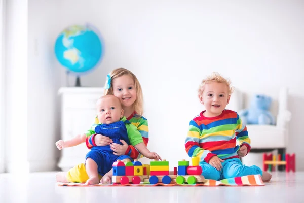 Niños jugando con tren de juguete de madera — Foto de Stock