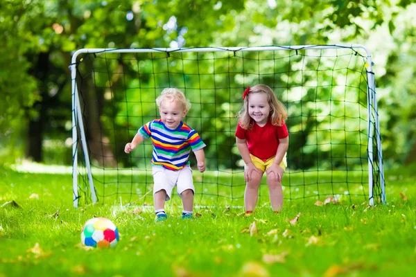 Okul bahçesinde futbol oynayan çocuklar