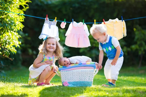 Niños jugando con su hermano recién nacido — Foto de Stock