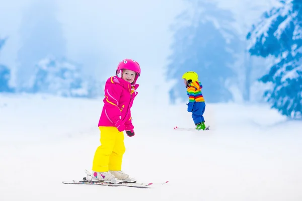 Deux enfants skient dans les montagnes enneigées — Photo