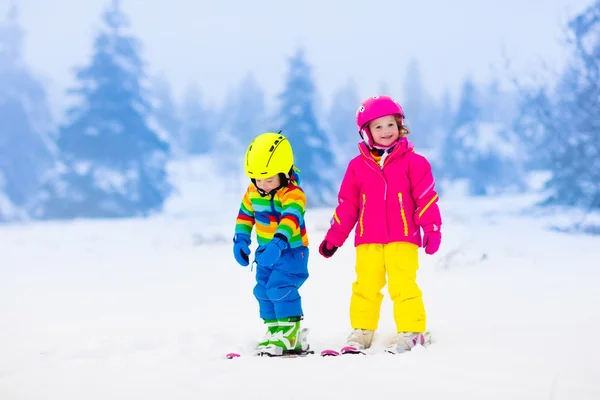 Två barn skidåkning i snötäckta berg — Stockfoto