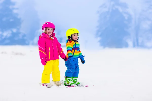 Due bambini sciano sulle montagne innevate — Foto Stock