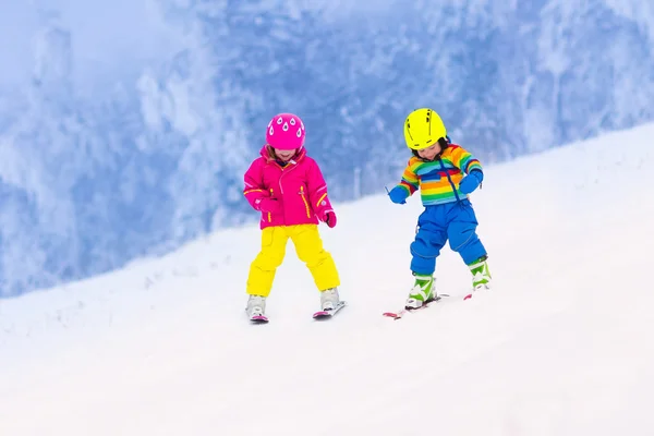 Twee kinderen skiën in besneeuwde bergen — Stockfoto