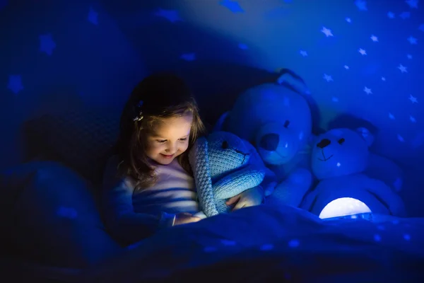 Niña leyendo un libro en la cama — Foto de Stock