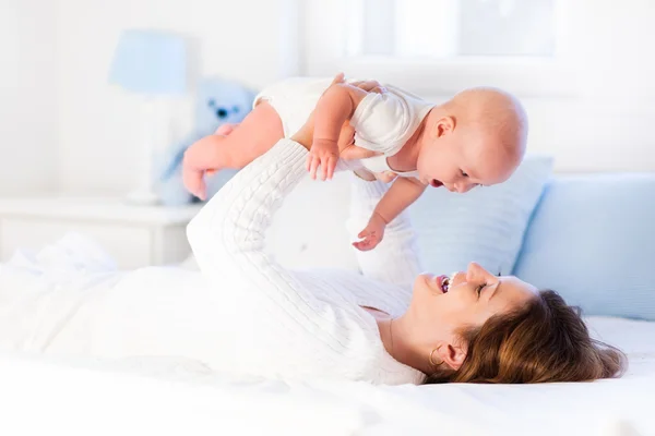 Mãe e bebê em uma cama branca — Fotografia de Stock