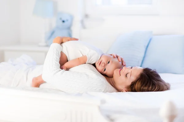 Madre e bambino su un letto bianco — Foto Stock