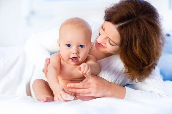 Mãe e bebê em uma cama branca — Fotografia de Stock