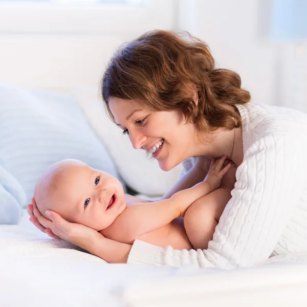 Madre y bebé en una cama blanca —  Fotos de Stock
