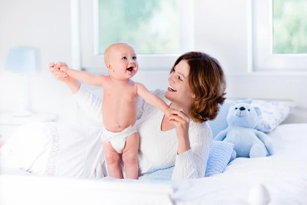 Madre e bambino su un letto bianco — Foto Stock