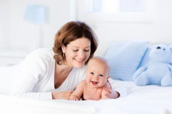 Anya és a baba egy fehér ágy — Stock Fotó
