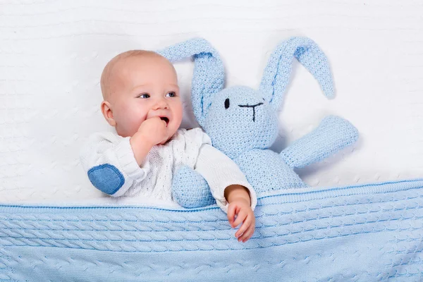 Bebê menino brincando com azul de malha coelho brinquedo — Fotografia de Stock