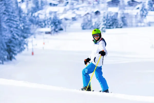 Esquí infantil en las montañas. Niño adolescente activo con casco de seguridad, gafas y postes. Carrera de esquí para niños pequeños. Deportes de invierno para la familia. Clases de esquí para niños en la escuela alpina. Esquiador de carreras en nieve — Foto de Stock