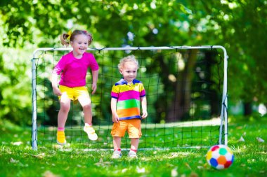 Okul bahçesinde futbol oynayan çocuklar