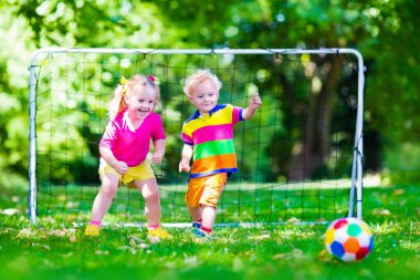 Okul bahçesinde futbol oynayan çocuklar
