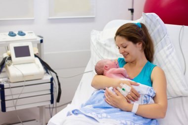 Young mother giving birth to a baby clipart