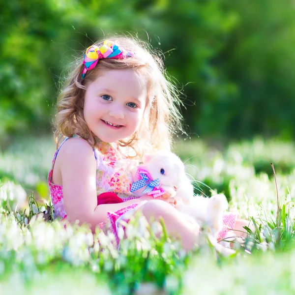 Kleines Mädchen spielt mit einem Kaninchen — Stockfoto