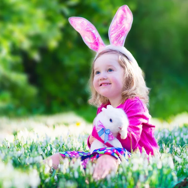 Kleines Mädchen spielt mit einem Kaninchen — Stockfoto