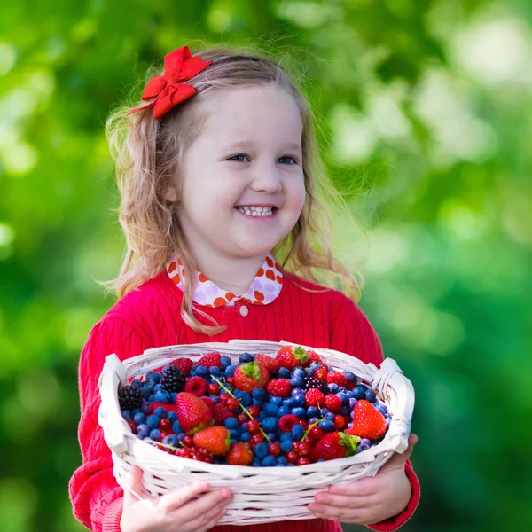 Little girl with fresh berries in a basket — Stock Photo, Image