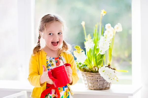 Mała dziewczynka podlewania wiosennych kwiatów — Zdjęcie stockowe