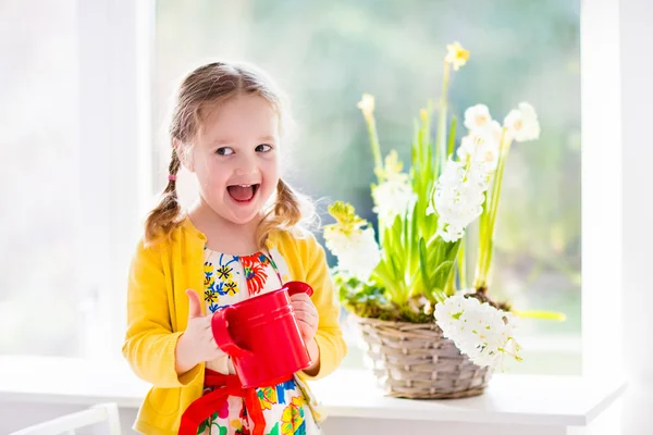 Liten flicka vattning vårblommor — Stockfoto