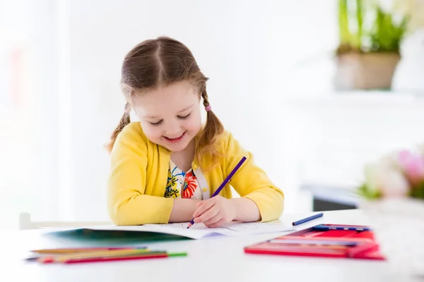 Klein meisje schilderen en schrijven — Stockfoto