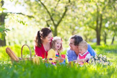 Family enjoying picnic in blooming garden