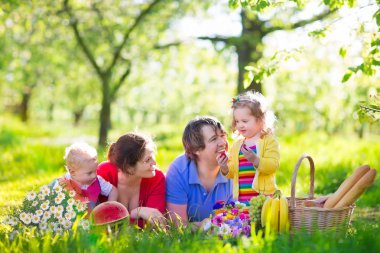 Family enjoying picnic in blooming garden