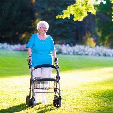 Senior handicapped lady with a walker in a park