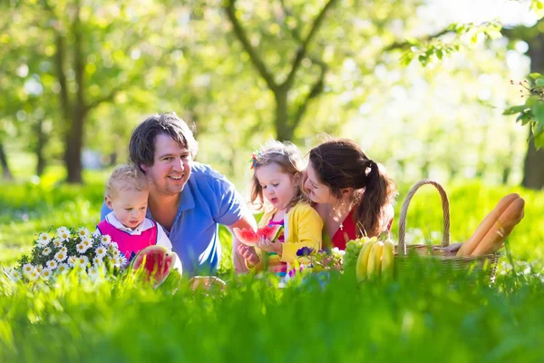 Familie genießt Picknick im blühenden Garten — Stockfoto