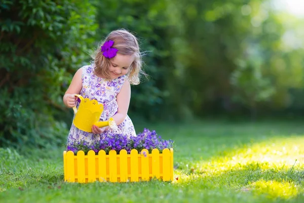 Kleines Mädchen beim Gießen fardener Blumen — Stockfoto