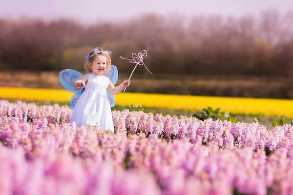 Kleines Mädchen spielt im Hyazinthenfeld — Stockfoto