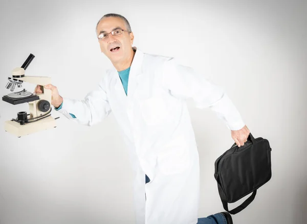 Doktor Evrak Çantası Mikroskopla Beyaz Arka Planda Komik Hareketler Yapıyor — Stok fotoğraf