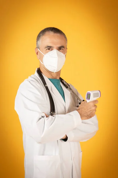 Koruyucu Maskeli Termometresi Olan Doktor Sarı Arka Plan — Stok fotoğraf