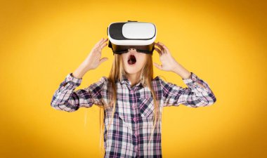 Sarı arka planda sanal gerçeklik gözlüklü bir kız.