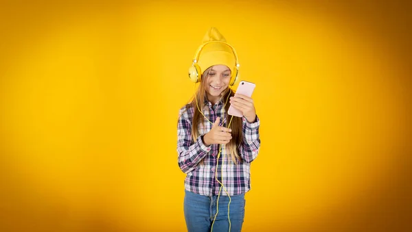 Ragazza Bionda Ascolta Musica Con Tuo Cellulare Background Giallo — Foto Stock