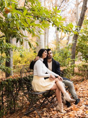 Parktaki bankta oturan birbirine aşık çift.